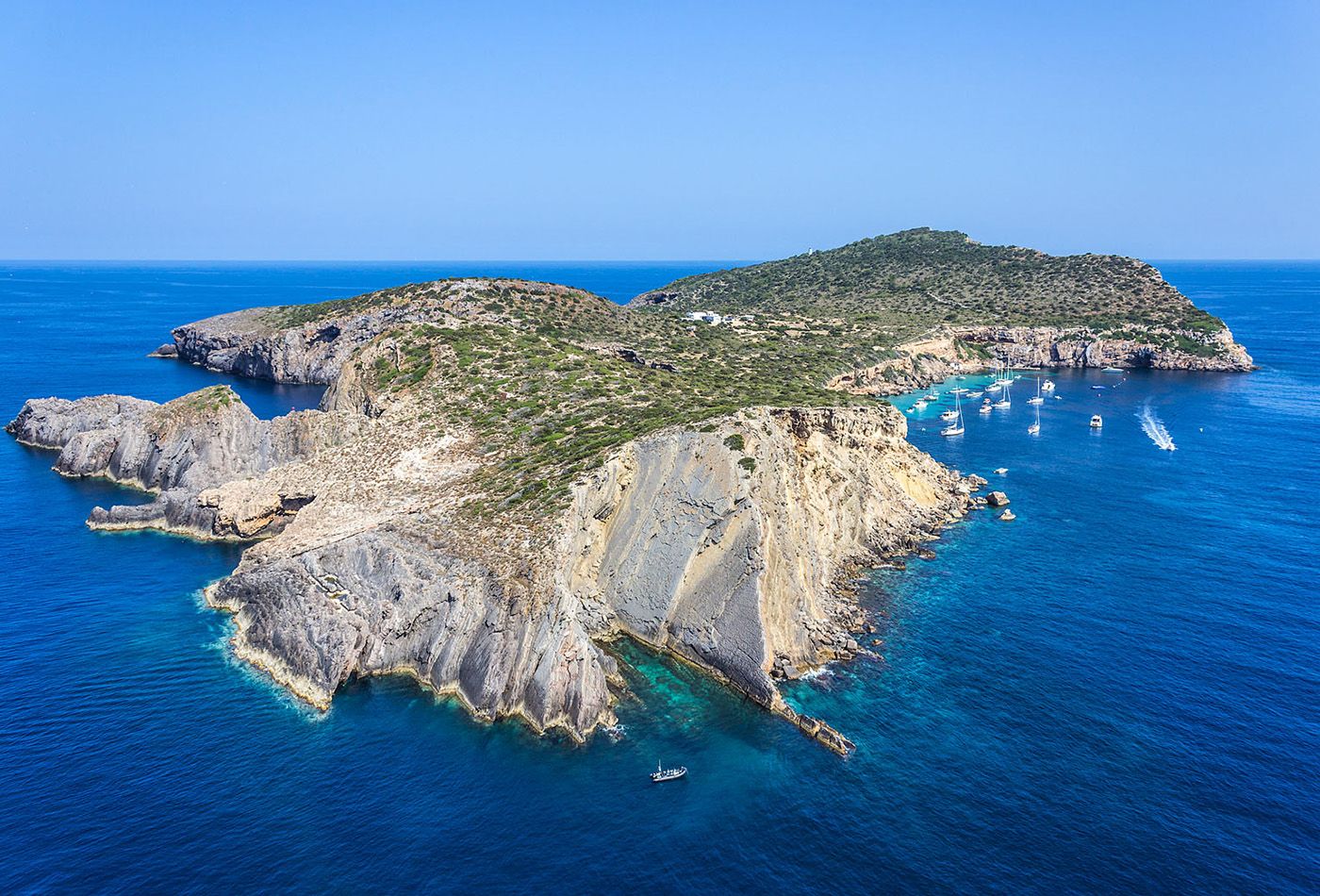 Drone shot of island in the sun with deep blue sea