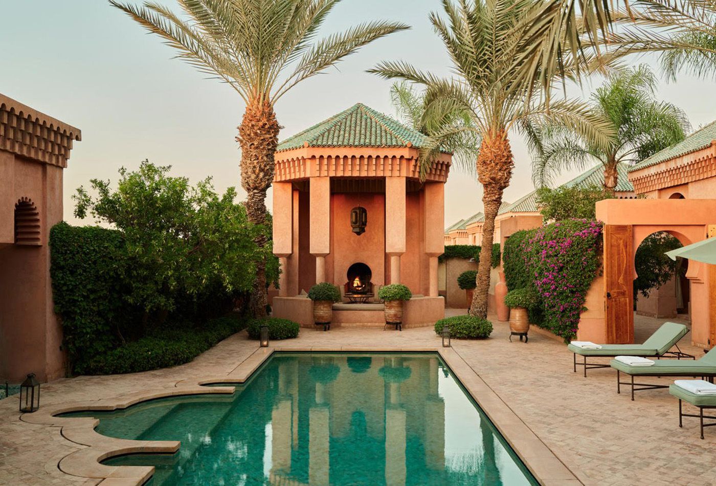 Terracotta maison and palm trees surround a secluded private swimming pool