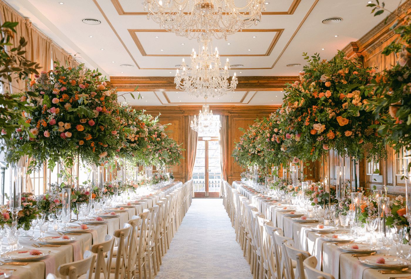 Long dining table wedding set up with small floral tree's lining the centre of the tables