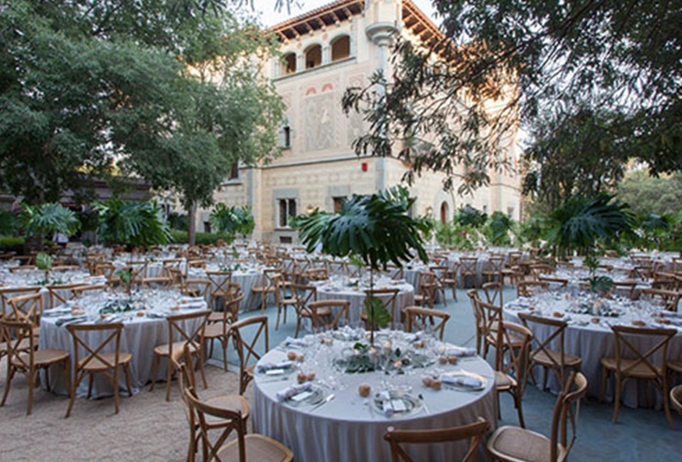 Outdoor wedding reception, round white tables with wooden chairs surrounded by trees and the grand Bell Reco in the background