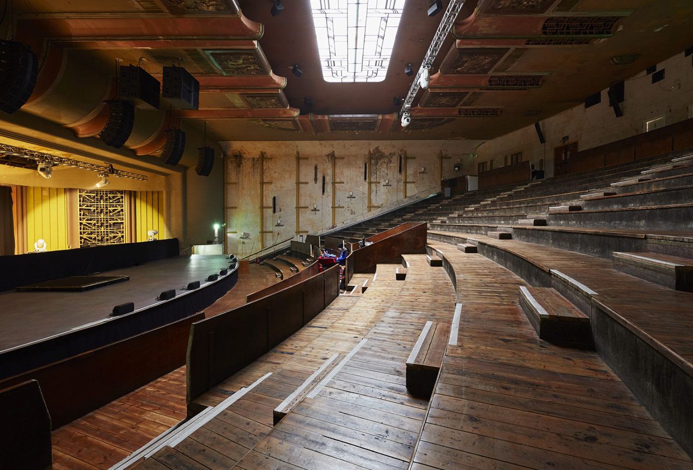 Side view of revamped warehouse with wooden staggered seating and stage