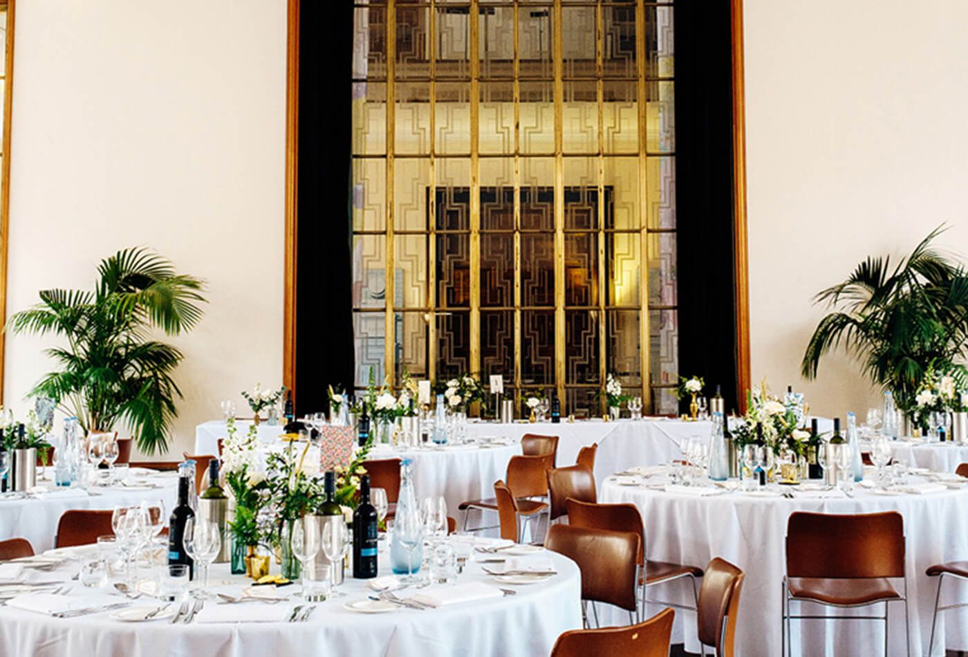 White wedding with green plants and brown leather chairs