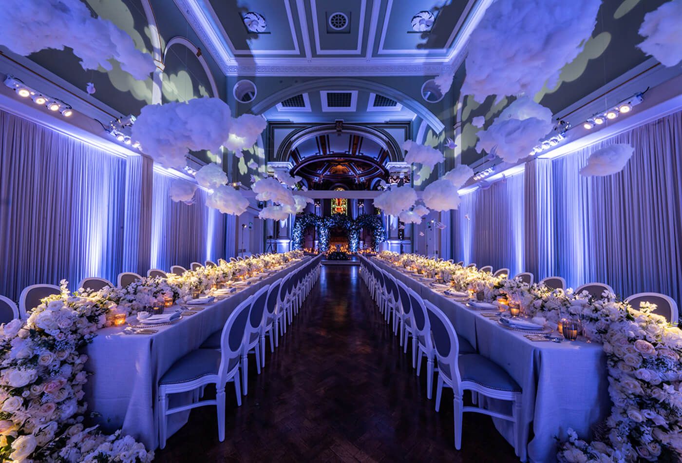 Wedding set up - long dining tables with rose centre pieces and pale purple lighting