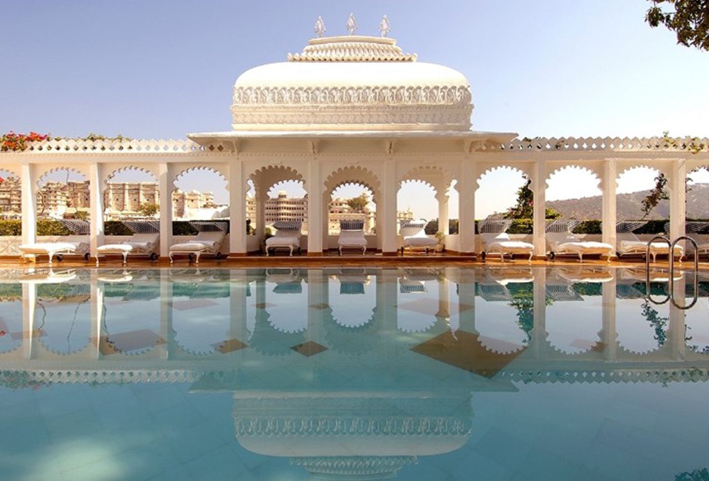 Large swimming pool with impressive white marble building 