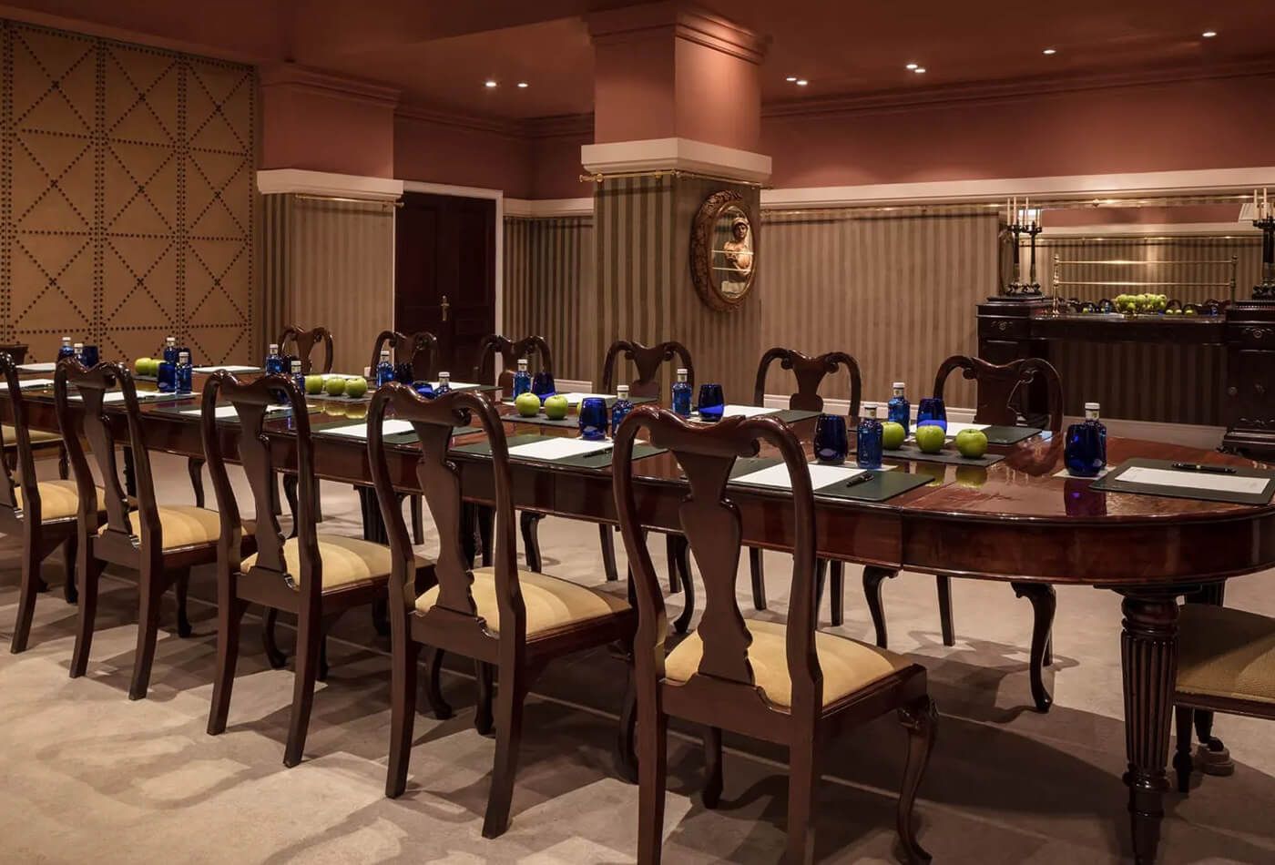 Long mahogany dining table with panelled walls