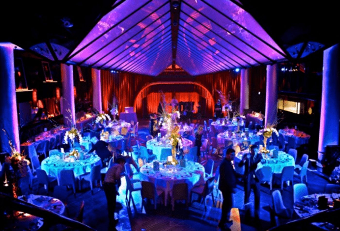 Dining area at night lit with blues, purples and reds