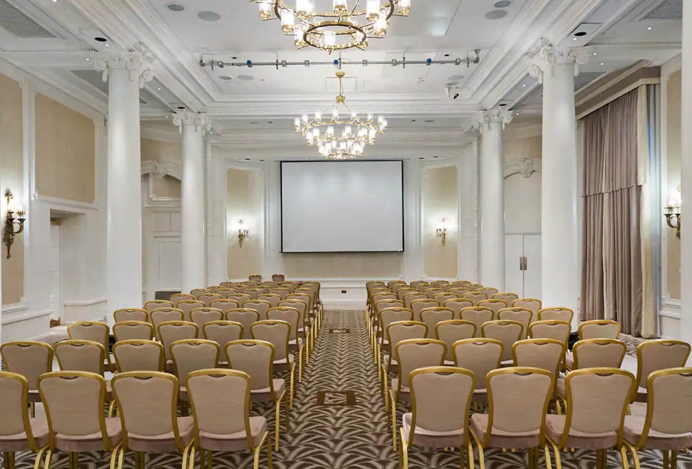 Gold and creme conference set up with high ceilings and large white pillars