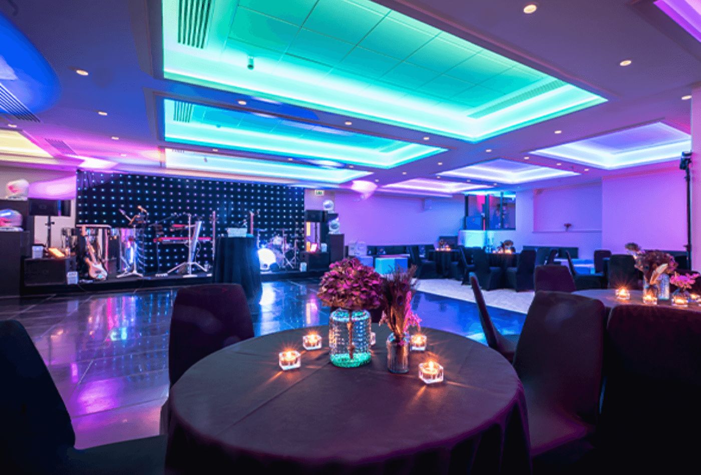 Dance floor with stage and ceiling lit up in turquoise