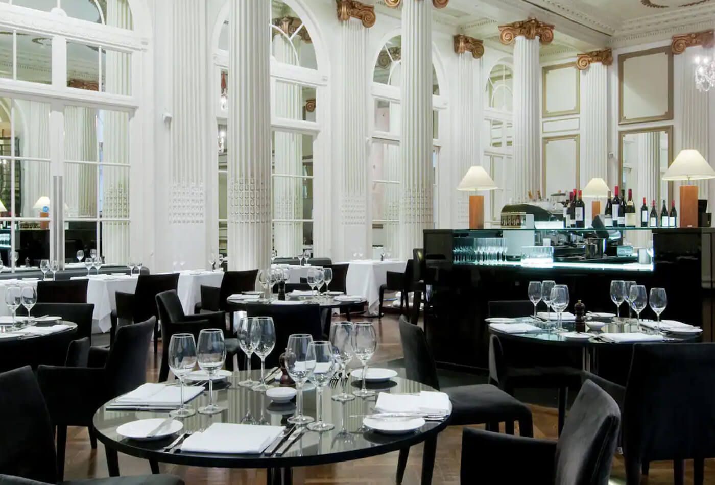 Black and white dining room with high ceilings and white pillars