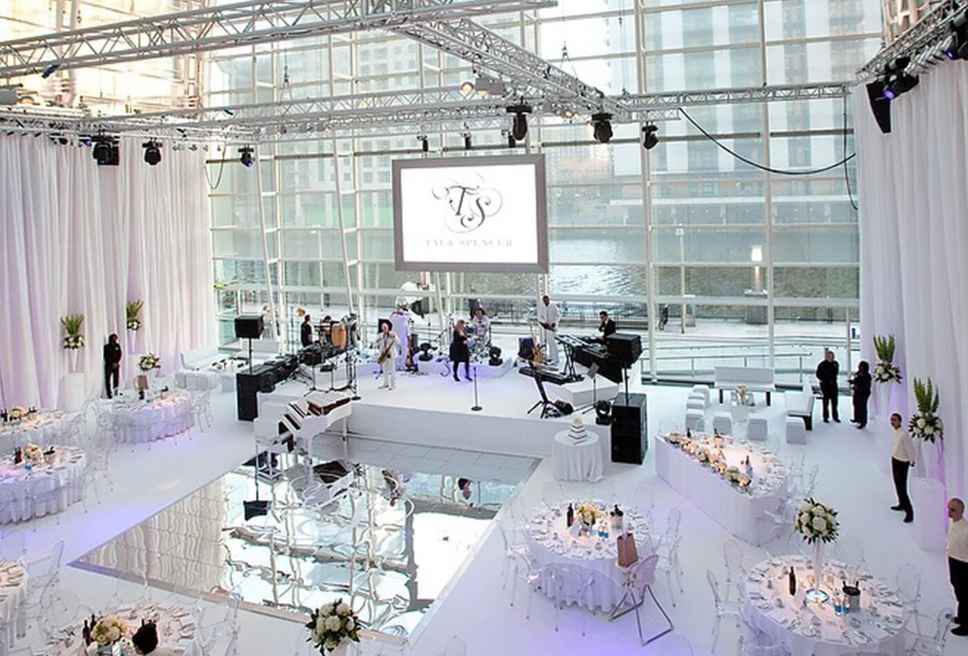 Completely white wedding set up, dining tables and stage
