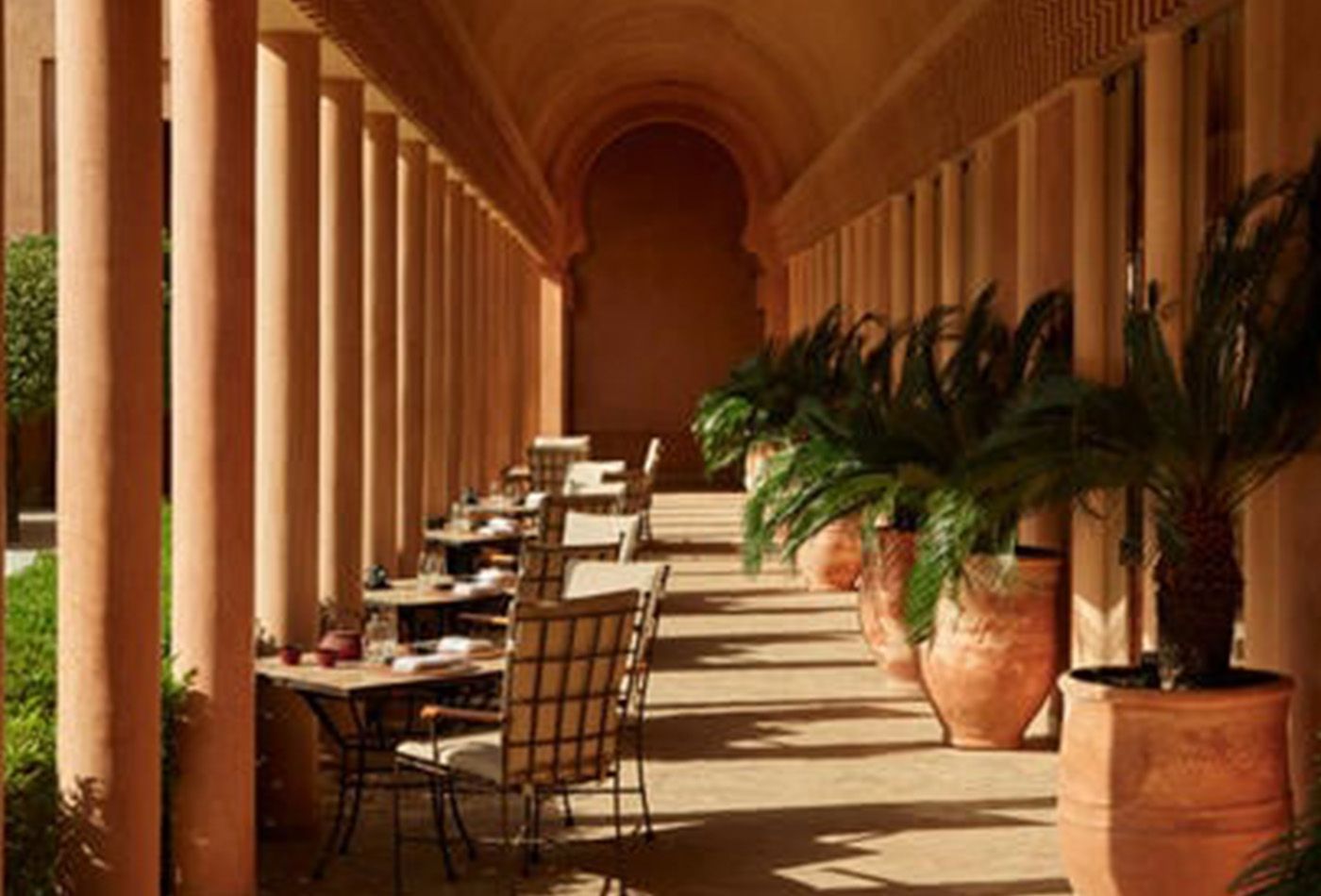 Outdoor seating area with large plants overlooking gardens 