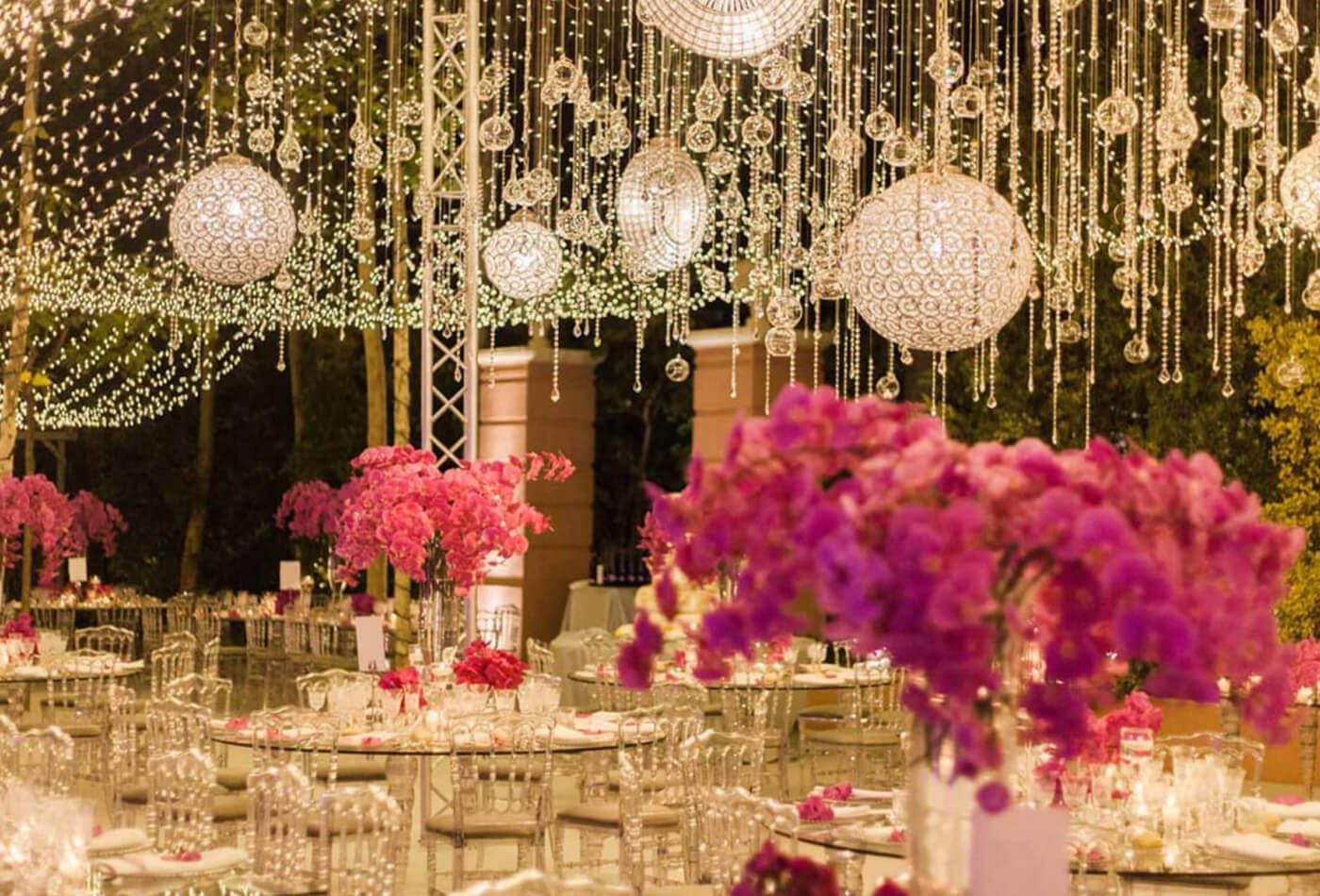 Transparent wedding tables with bright pink floral arrangements